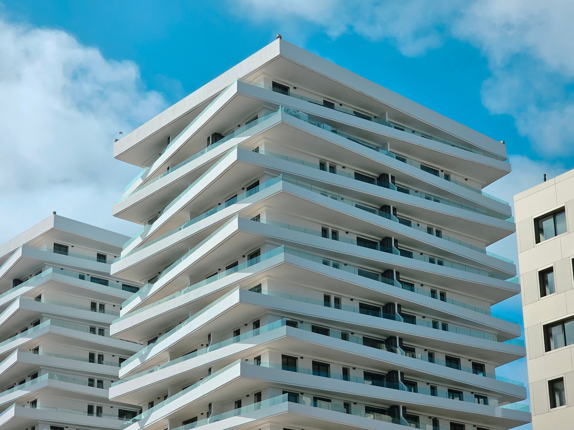 Sleek Symmetry: Contemporary Apartment Architecture with Angled Balconies low angle view Sleek Symmetry: Contemporary Apartment Architecture with Angled Balconies low angle view
